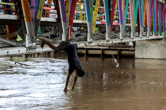 Aksi Nekat Anak-Anak Lompat ke Sungai Ciliwung yang Meluap