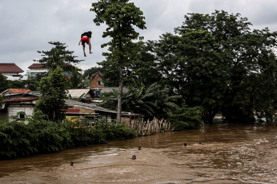 Aksi Nekat Anak-Anak Lompat ke Sungai Ciliwung yang Meluap