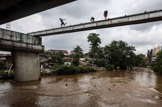 Aksi Nekat Anak-Anak Lompat ke Sungai Ciliwung yang Meluap
