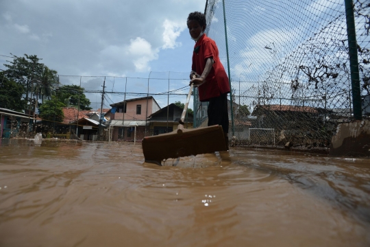 Warga Rawa Jati Bersihkan Lumpur Banjir