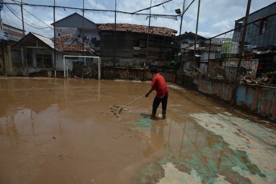 Warga Rawa Jati Bersihkan Lumpur Banjir