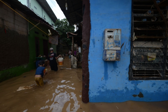 Warga Rawa Jati Bersihkan Lumpur Banjir