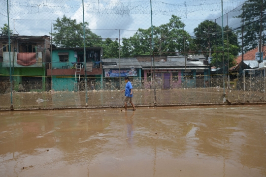 Warga Rawa Jati Bersihkan Lumpur Banjir