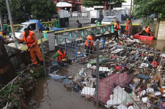 Aksi Petugas UPK Badan Air DLH DKI Bersihkan Sumbatan Sampah di Kali Mampang