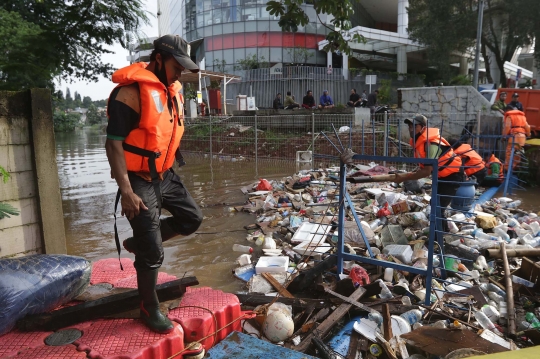 Aksi Petugas UPK Badan Air DLH DKI Bersihkan Sumbatan Sampah di Kali Mampang