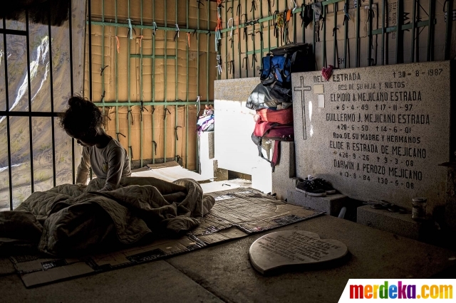 Seorang gadis beristirahat di sebuah gubuk yang dibangun keluarganya di pemakaman umum di Caracas, Venezuela, pada 10 Februari 2021. Sebuah pemakaman di Caracas telah menjadi rumah bagi banyak tunawisma yang rela hidup berdampingan dengan orang mati karena tak lagi memiliki tempat tinggal.