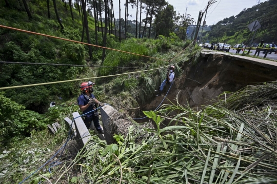 Guyuran Hujan Lebat Sebabkan Tanah Ambles di Pinggir Jalan