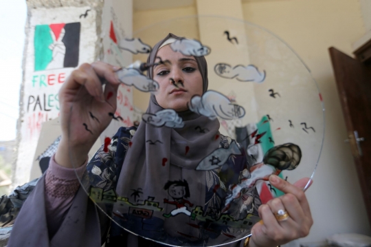 Kreativitas Seniman Cantik Palestina Melukis Karyanya di Atas Puing