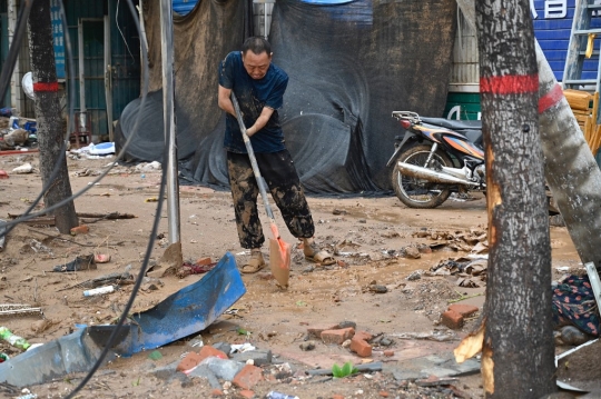 Warga Henan Bersih-Bersih Usai Hantaman Banjir Bandang