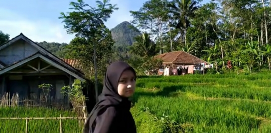 Potret Gadis Desa Cantik Berkerudung Hitam Main di Sawah Sambil Lambaikan Tangan