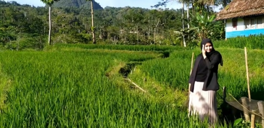 Potret Gadis Desa Cantik Berkerudung Hitam Main di Sawah Sambil Lambaikan Tangan