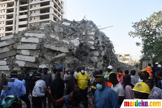 Kerumunan orang melihat kondisi bangunan apartemen yang sedang dalam pengerjaan runtuh di Distrik Ikoyi, Lagos, pada 1 November 2021. Beberapa orang yang sebagian besar pekerja konstruksi telah terperangkap dalam bangunan 21 lantai tersebut. Sementara, jumlah orang yang tidak ditentukan dikhawatirkan tewas.