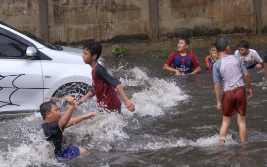 Ketika Banjir Jadi Arena Bermain Anak-Anak