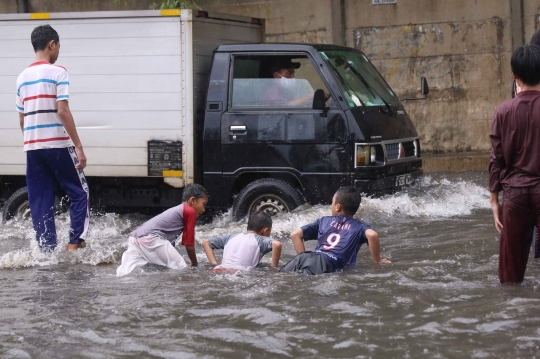 Ketika Banjir Jadi Arena Bermain Anak-Anak