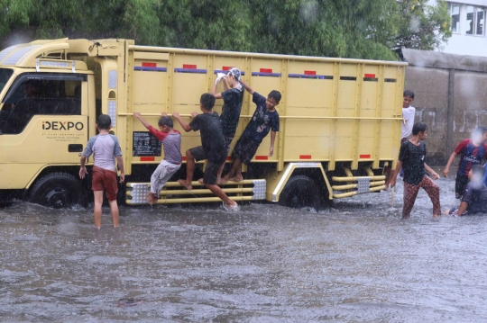 Ketika Banjir Jadi Arena Bermain Anak-Anak