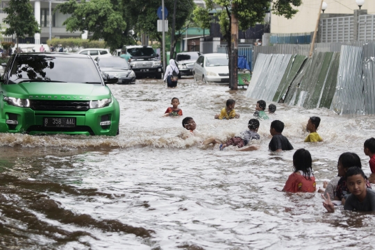 Anak-Anak Bermain Air saat Banjir Merendam Jalan Bungur Besar Raya