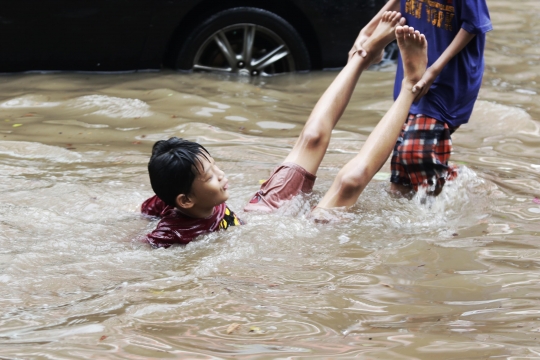 Anak-Anak Bermain Air saat Banjir Merendam Jalan Bungur Besar Raya