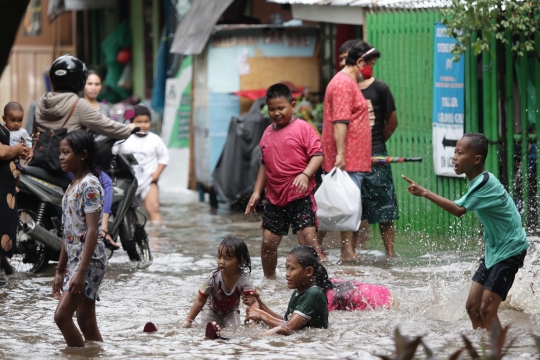 Anak-Anak Bermain Air saat Banjir Merendam Jalan Bungur Besar Raya