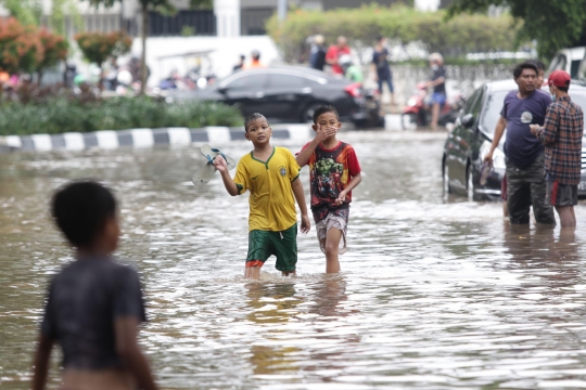 Anak-Anak Bermain Air saat Banjir Merendam Jalan Bungur Besar Raya