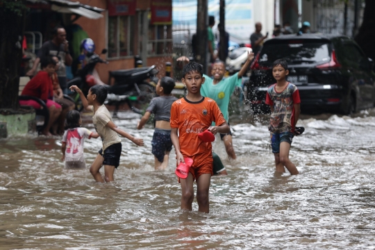 Anak-Anak Bermain Air saat Banjir Merendam Jalan Bungur Besar Raya