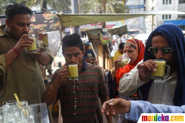 Warga menikmati minuman jus tebu di tengah musim panas ekstrem melanda Karachi, Paksitan (17/5/2022). Satu miliar jiwa telah merasakan suhu tinggi yang melebihi 45 derajat Celcius melanda Pakistan dan sekitarnya.