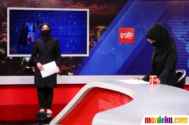 Presenter wanita untuk Tolo News, Khatereh Ahmadi, menggunakan cadar atau kain untuk menutupi wajahnya saat membacakan berita di ruang redaksi stasiun TV Tolo di Kabul, Afghanistan (22/5/2022).
