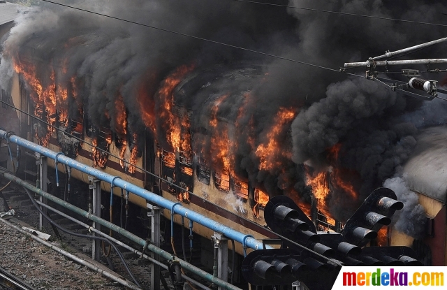 Asap mengepul dari gerbong kereta penumpang setelah dibakar oleh pengunjuk rasa di Secunderabad, negara bagian selatan Telangana, India, pada 17 Juni 2022. Kerusuhan pecah saat pengunjuk rasa menentang keras 