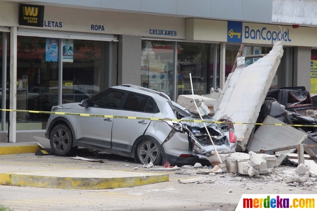 Kondisi sebuah mobil yang tertimpa reruntuhan fasad department store setelah terjadi gempa di Manzanillo, Meksiko, pada 19 September 2022. Gempa berkekuatan magnitudo (M) 7,4 mengguncang wilayah Meksiko. 