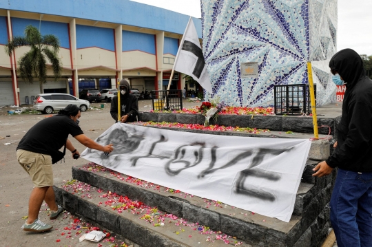 Aremania Tebar Bunga di Monumen Singa Tegar Stadion Kanjuruhan