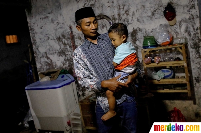 Andi Hariyanto (36) menggendong putranya yang berusia 2 tahun, Gean Putra Hariyanto di rumahnya di Malang, Jawa Timur, pada 4 Oktober 2022. Menyaksikan pertandingan Arema FC di Stadion Kanjuruhan adalah hal yang sering kali dilakukan oleh Andi dan keluarganya. Namun, siapa menyangka laga yang berlangsung pada Sabtu (1/10) malam itu berujung kerusuhan sehingga menewaskan istri dan dua putri Andi.