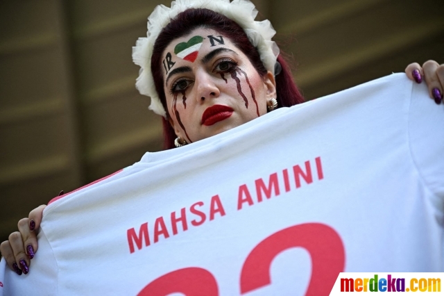 Suporter Iran menunjukkan kaos untuk mengenang kematian Mahsa Amini selama pertandingan Wales vs Iran di laga grup B Piala Dunia 2022 di Ahmad Bin Ali Stadium, Al Rayyan, Qatar, Jumat (25/11/2022).