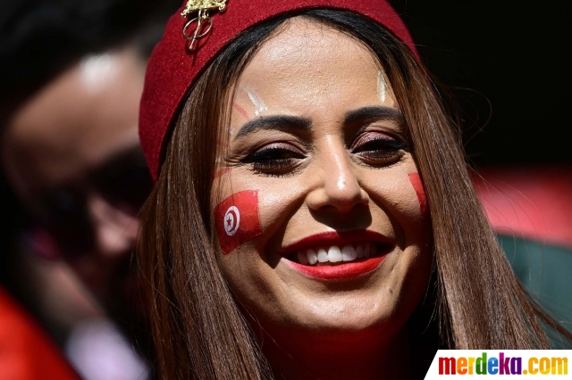 Seorang suporter wanita Tunisia tersenyum saat menyaksikan laga Tunisia vs Australia dalam babak penyisihan Grup D Piala Dunia 2022 di Stadion Al-Janoub, Al-Wakrah, Qatar, Sabtu (26/11/2022). 