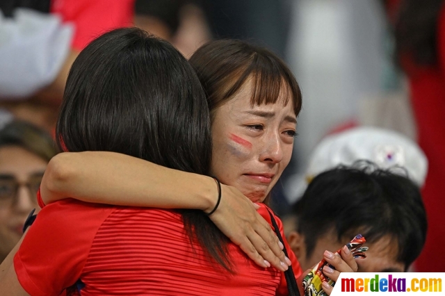 Seorang suporter wanita Korea Selatan menangis seusai laga Korea Selatan vs Ghana dalam babak penyisihan Grup G Piala Dunia 2022 di Education City Stadium, Al Rayyan, Qatar, Senin (28/11/2022).