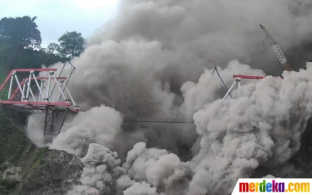Dalam foto yang diambil dan dirilis Badan Geologi Indonesia pada Minggu (4/12/2022) ini memperlihatkan jembatan Glada Perak yang sedang dalam proses rekonstruksi terkena terjangan debu vulkanik panas dari letusan Gunung Semeru di Lumajang. 