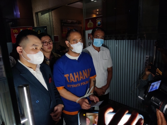 Foto Ferry Irawan dengan Tangan Terikat dan Berbaju Biru Bertulis Tahanan