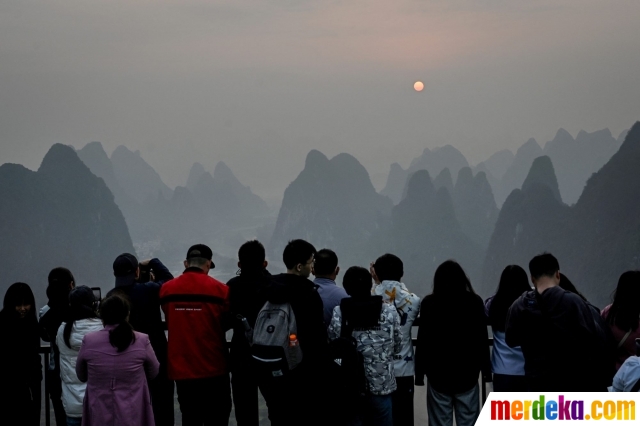 Wisatawan menikmati keindahan pemandangan gugusan pegunungan Xianggong, China, Selasa (21/2/2023).