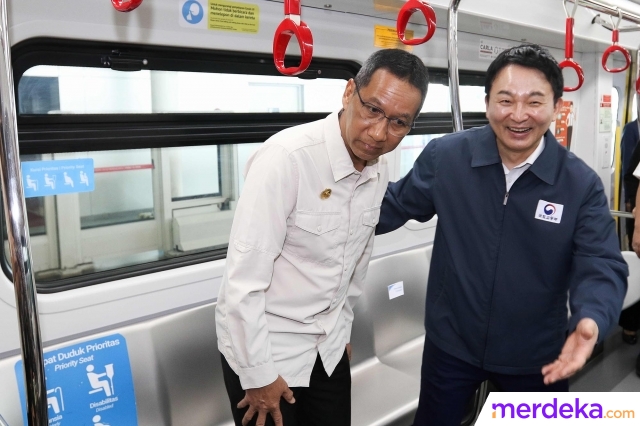 Penjabat (Pj) Gubernur DKI Jakarta Heru Budi Hartono bersama Menteri Agraria, Infrastruktur, dan Transportasi Korea Selatan Won Hee-ryong (kanan) menaiki kereta Light Rail Transit (LRT) di Stasiun LRT Pegangsaan Dua, Jakarta, Jumat (17/3/2023).