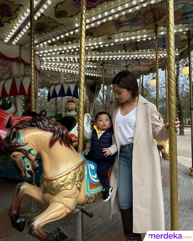 Nikita mengajak Baby Izz ke Tuileries Garden, Paris. Tuileries Garden merupakan taman luas yang cocok untuk santai bersama keluarga. Pada potret ini, baby Izz tengah naik wahana ditemani Nikita. 