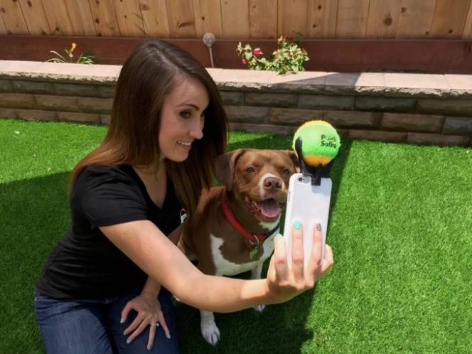 Seorang pengguna selfie dengan anjing peliharaan menggunakan perangkat Pooch Selfie.