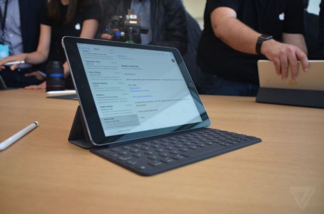 iPad Pro 9,7inci saat diletakkan dalam posisi berdiri bersama dengan keyboard dan stylus (foto tampak dari samping).