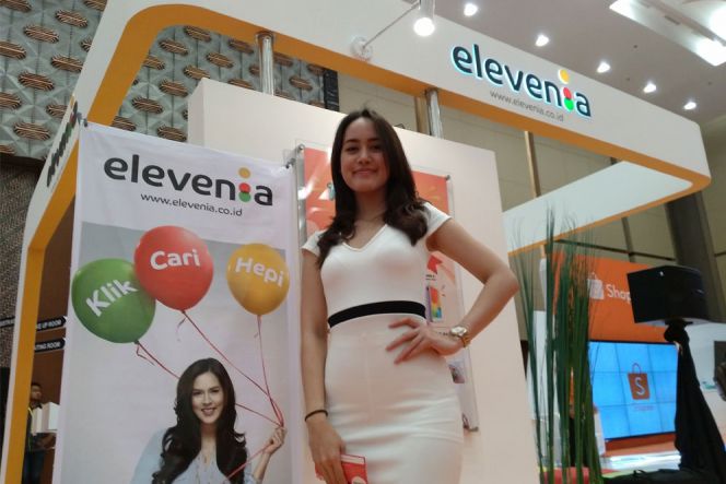 Berbodi aduhai, perempuan cantik mengenakan dress putih tak segan menarik para pengunjung supaya membuat akun di Elevenia. Beragam promosi disediakan layanan e-commerce yang mendapuk penanyi cantik Raisa sebagai brand ambassadornya di ajang IESE.