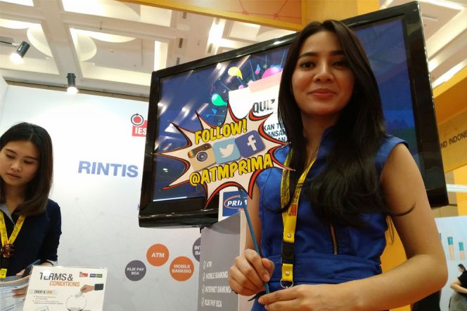 Kipas unik bergambar serangkaian logo media sosial populer lengkap dengan tulisan @ATMPRIMA dibawa-bawa perempuan manis berpakaian biru ini untuk mempromosikan akun resmi milik ATM Prima kepada pengunjung IESE.