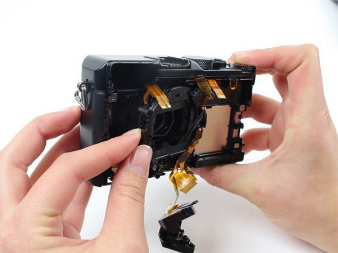 Setelah semua baut terlepas, Anda bisa mulai mengeluarkan casing lensa. Tetap lakukan dengan perlahan dan hati-hati agar tak menyebabkan kabel terputus.