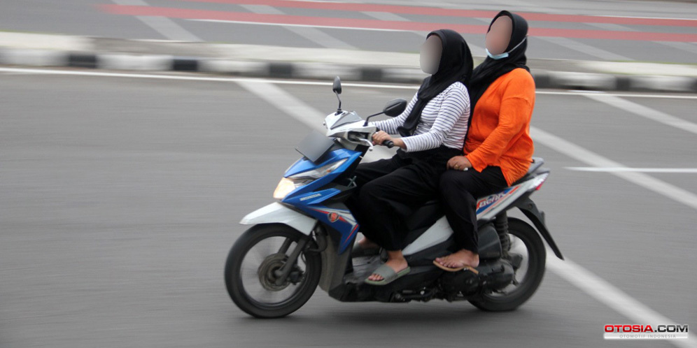 Pemotor wanita berboncengan tanpa helm dan hanya menggunakan sandal (Otosia.com/Nazar Ray)