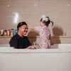 Di lain foto kamu juga bisa menemukan momen manis saat pasangan ayah dan anak ini mandi bareng dalam bathtub penuh busa.