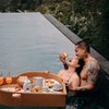 Terlebih lagi di lain foto juga ada momen ketika Miller menyuapi istrinya dengan croissant di kolam renang sambil menikmati fasilitas floating breakfast seperti ini.