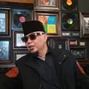Ahmad Dhani duduk di depan dinding penuh pigura