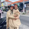 Jennifer Bachdim Pakai Jas Hujan