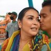 Sebelum naik bianglala, Ajun Perwira mencium mesra pipi sang istri. 