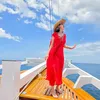 Luna Maya pakai dress merah di atas perahu